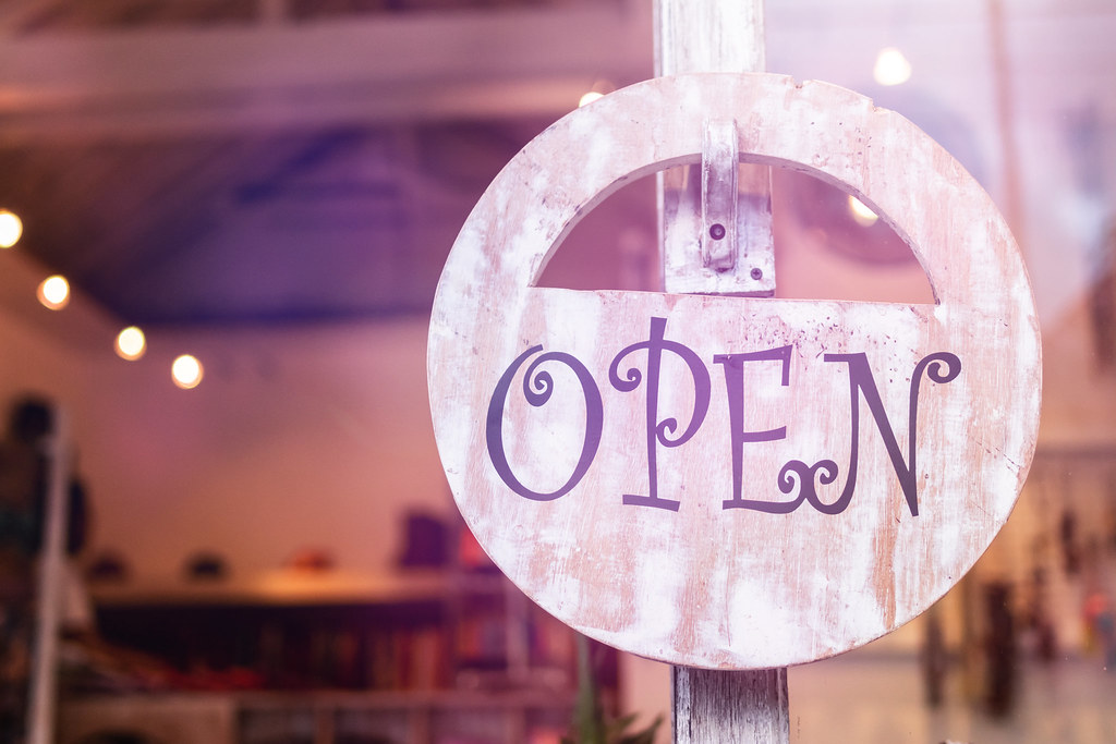 店の窓辺に下げられた木製のOPENの看板