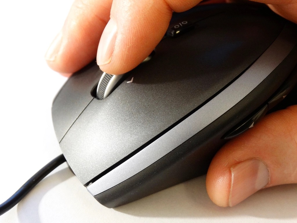手がマウスを握り、ホイールに指をかけている接写